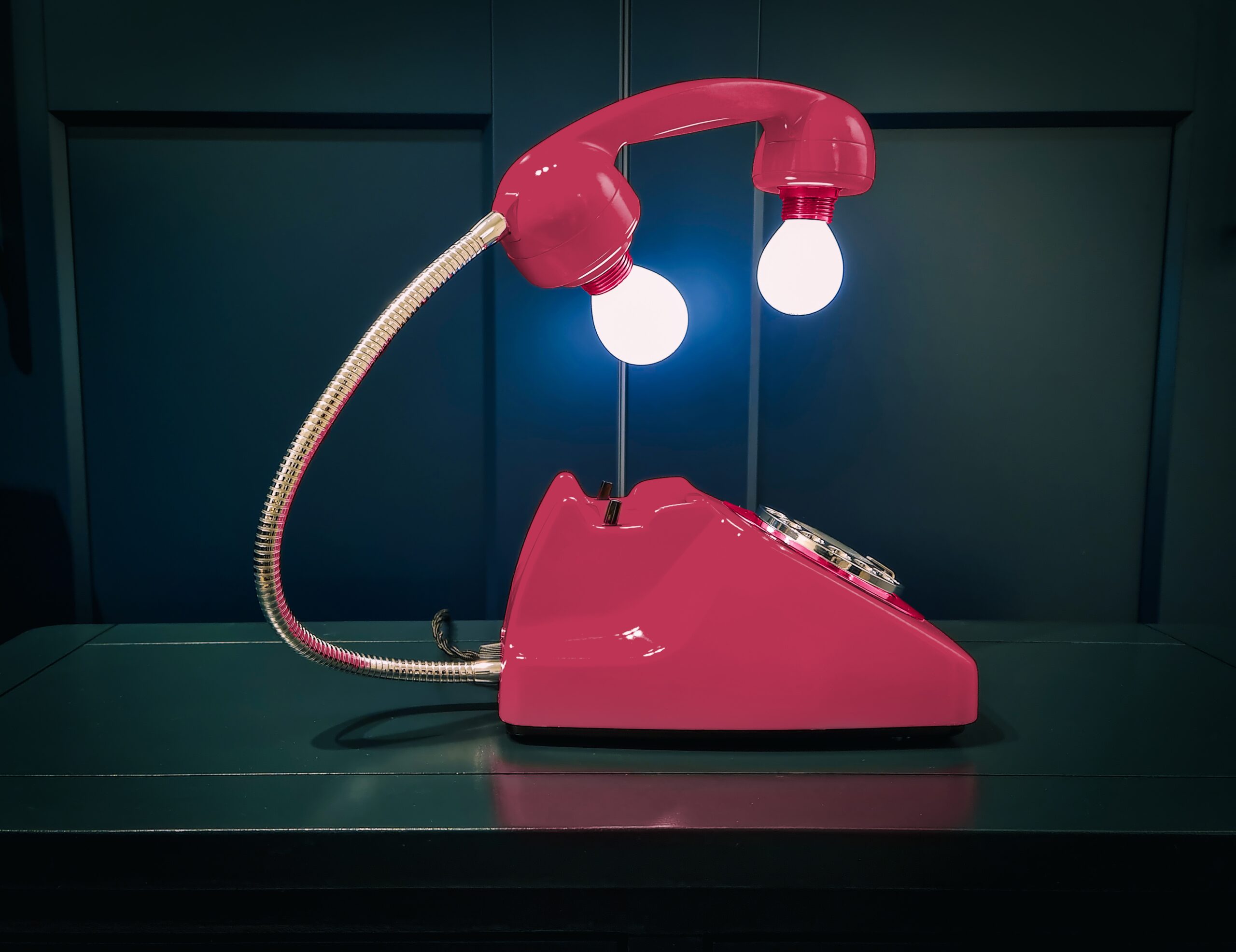 a pink telephone sitting on top of a table