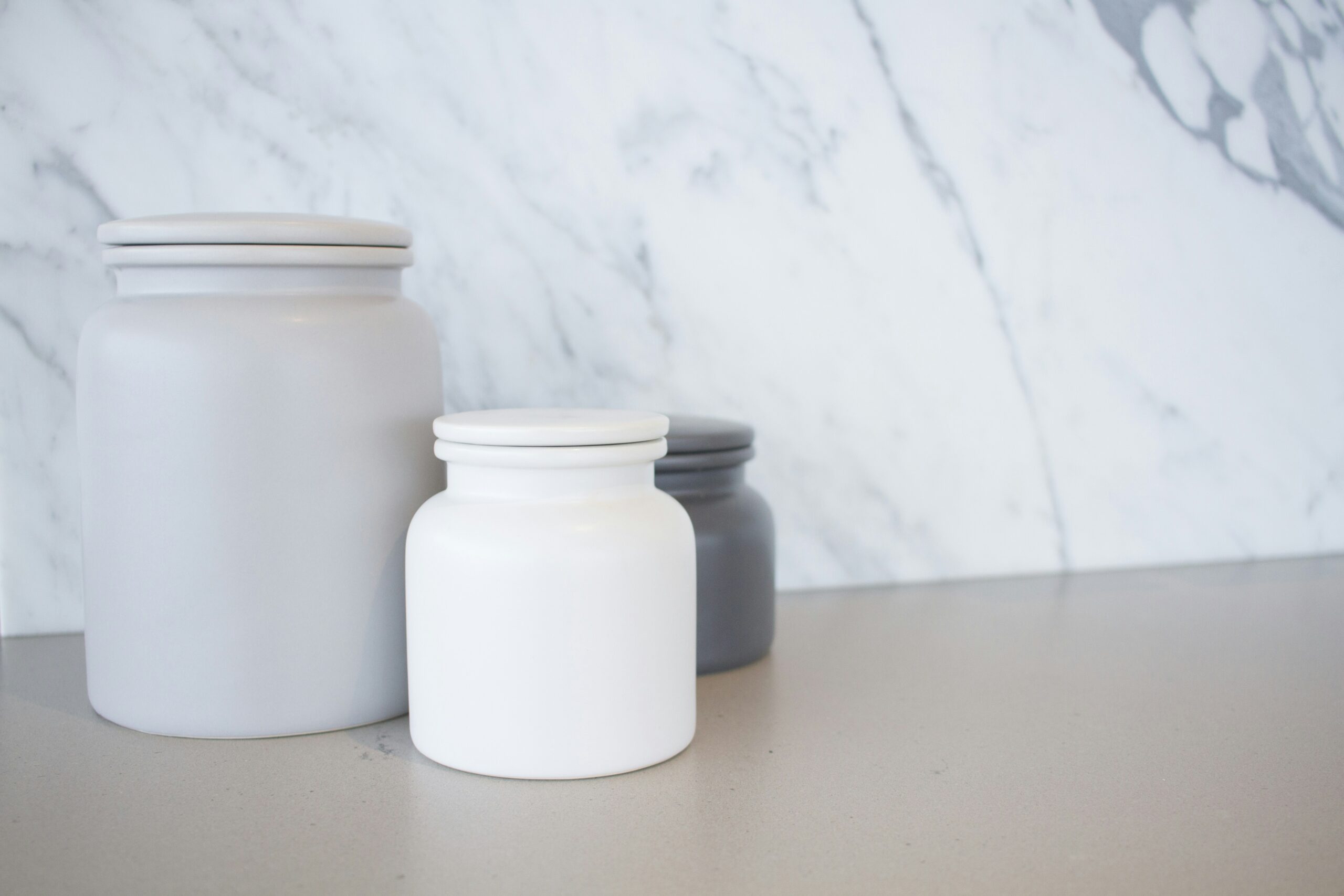 three jars sitting on a counter top next to each other